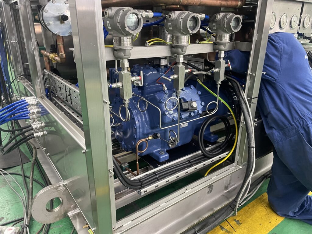 BOCK ATEX compressor installed in offshore explosion-proof condensing unit with Technician working on it
